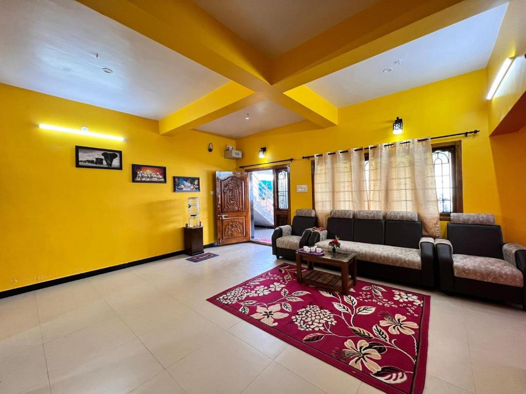 uma sala de estar com paredes amarelas e sofás e um tapete vermelho em Golden View Cottage Ooty em Ooty
