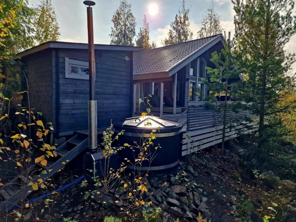 a tiny house with a hot tub on the porch at Villa Laiskajaakko in Vimpeli
