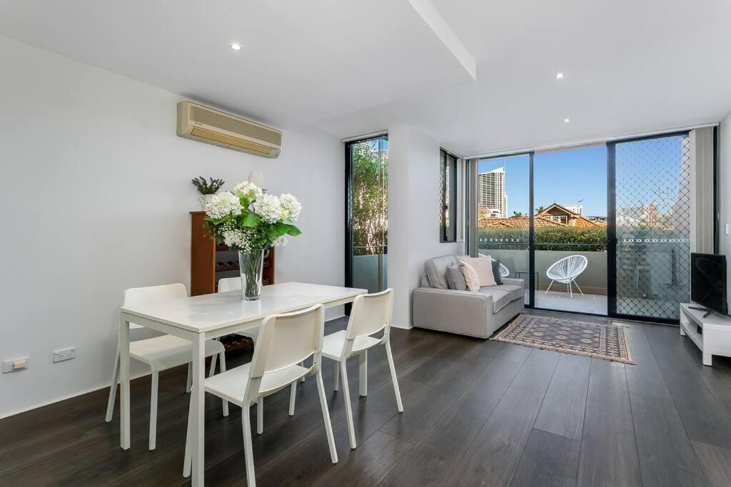 a white dining room with a white table and chairs at WILL1 - Stylish 2-Bed 2-Bath Oasis in Crows Nest Village in Sydney