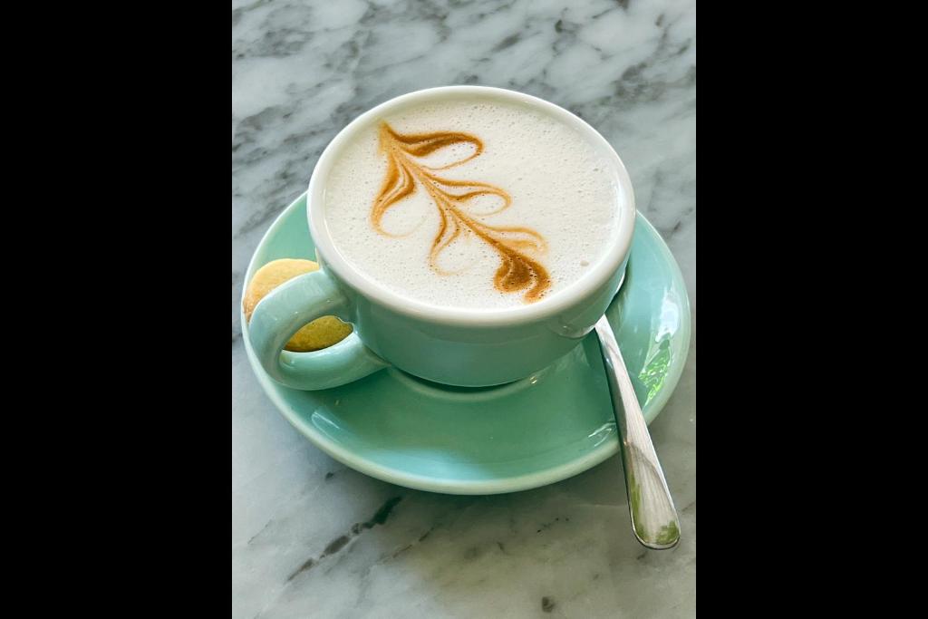 a cup of coffee on a plate on a table at Rascals Hotel - Adults Only in Kuta Lombok