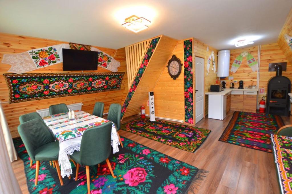 ein Esszimmer mit einem Tisch und Stühlen sowie eine Küche in der Unterkunft A frame Sima in Breb