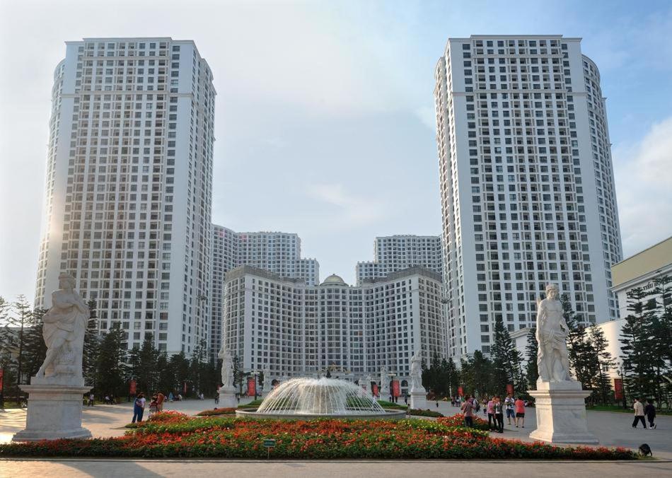 twee hoge gebouwen met een fontein in het midden van een stad bij Nhà Nghỉ Hương Thúy - TTTM Royal City in Hanoi