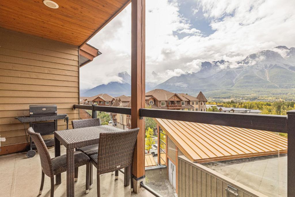 a balcony with a table and chairs and a view at Rockies Retreat by Canadian Rockies Vacation Rentals in Canmore