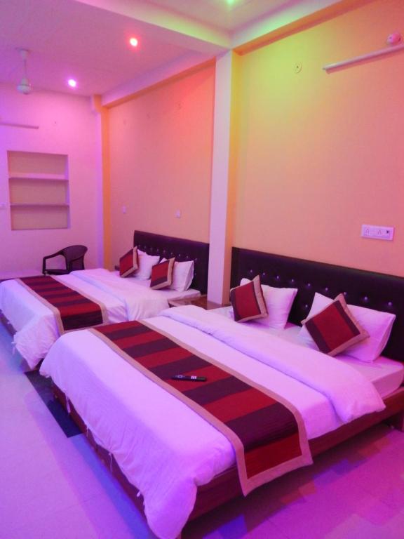 - 2 lits dans une chambre avec des lumières violettes dans l'établissement Ranthambhore Tiger Hut, à Sawai Madhopur