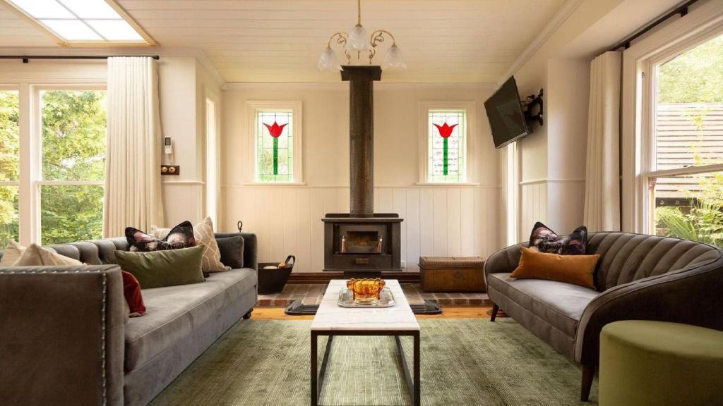 a living room with two couches and a fireplace at Isabellas At Beechworth in Beechworth