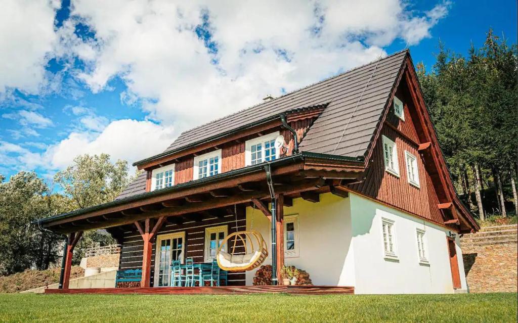 a large wooden house with a gambrel roof at Roubenka Ondřejník in Kunčice pod Ondřejníkem