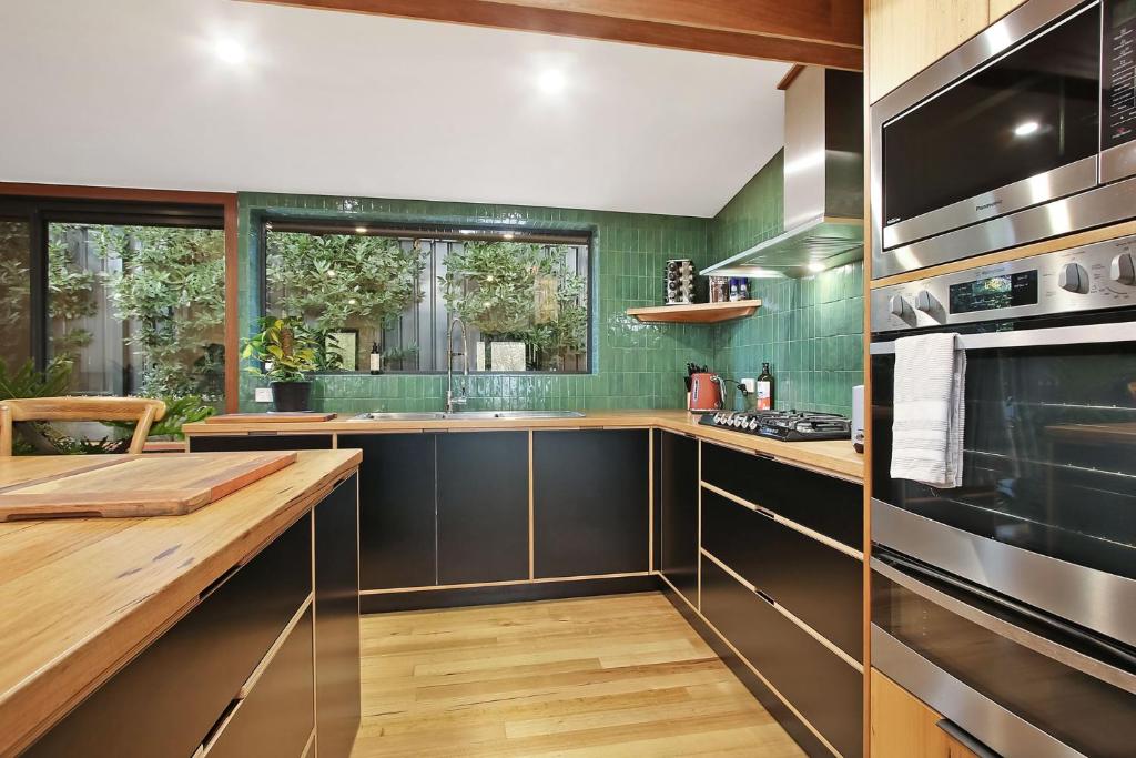 a kitchen with a counter and a sink and a stove at Millie & Pips Beechworth Bungalow in Beechworth