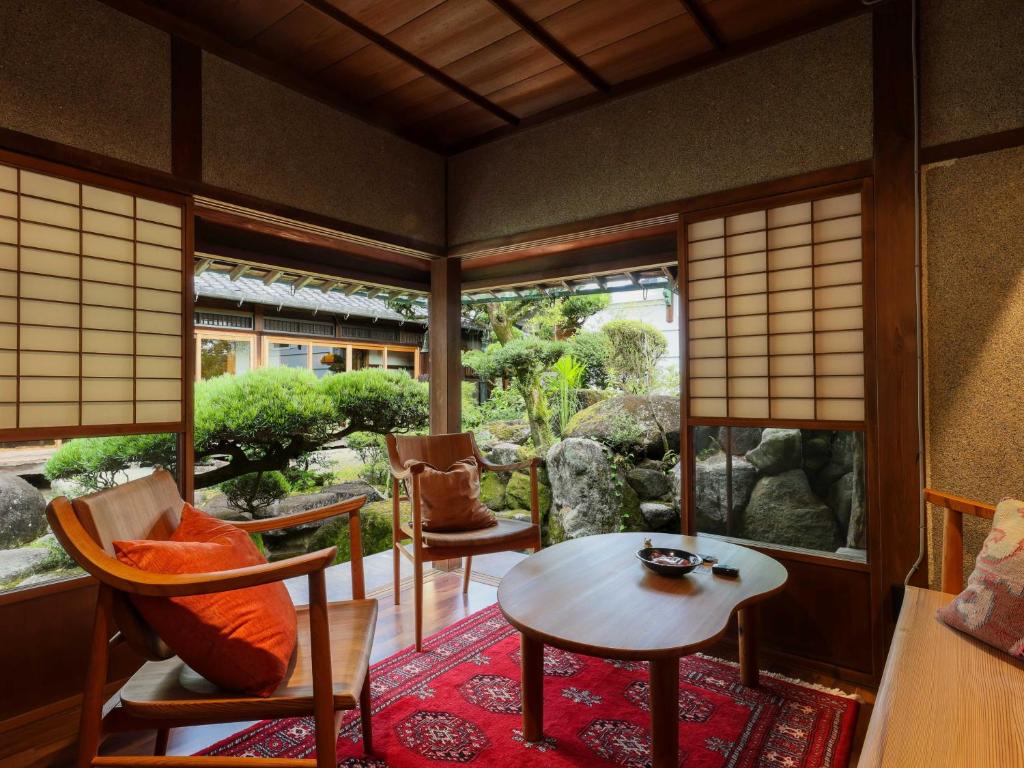 a room with a table and chairs and a window at NIPPONIA 田原本 マルト醤油 in Nara