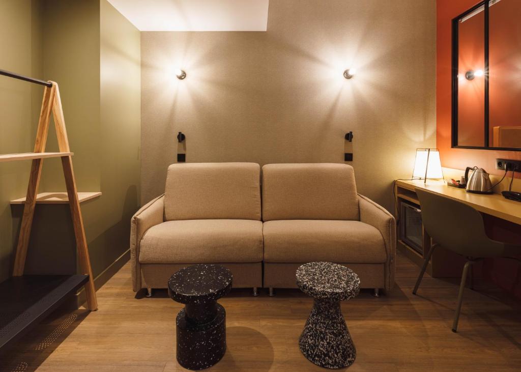 a living room with a couch and two tables at Hôtel de Noailles in Lyon