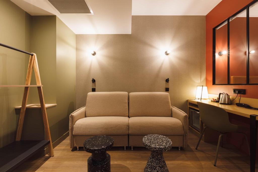 a living room with a couch and a desk at Hôtel de Noailles in Lyon