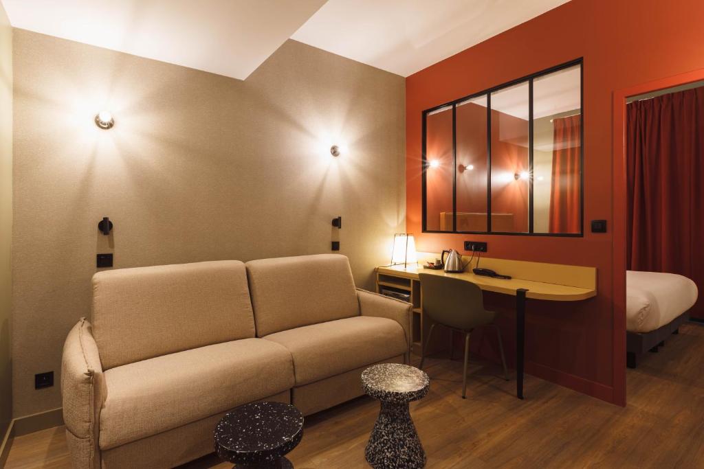 a living room with a couch and a bed at Hôtel de Noailles in Lyon