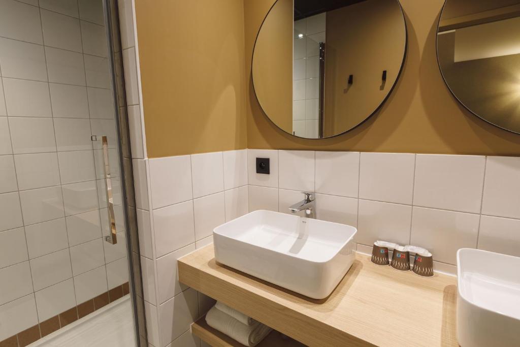 a bathroom with a white sink and a mirror at Hôtel de Noailles in Lyon