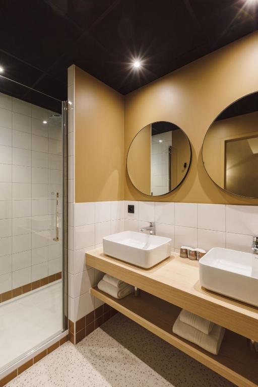 a bathroom with two sinks and a shower at Hôtel de Noailles in Lyon