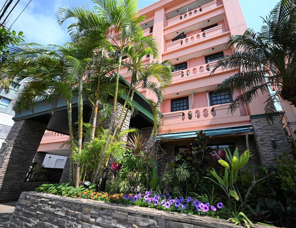 石垣島にあるホテルアビアンパナ石垣島のヤシの木と花のピンクの建物