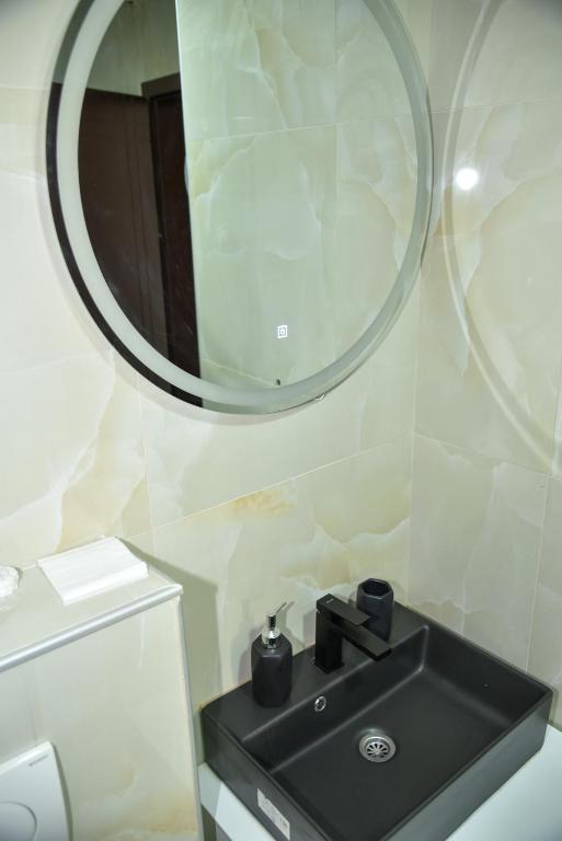 a bathroom with a black sink and a mirror at Apartmani COLOSSEUM in Bratunac