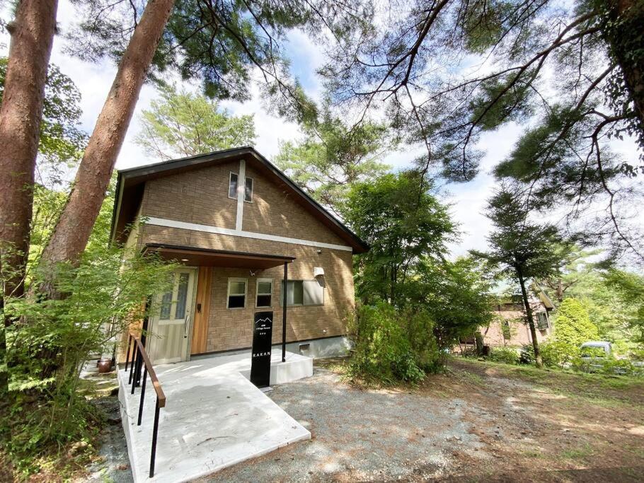 a small house with a porch in the woods at 南阿蘇Villagehouseらかん in Minami Aso