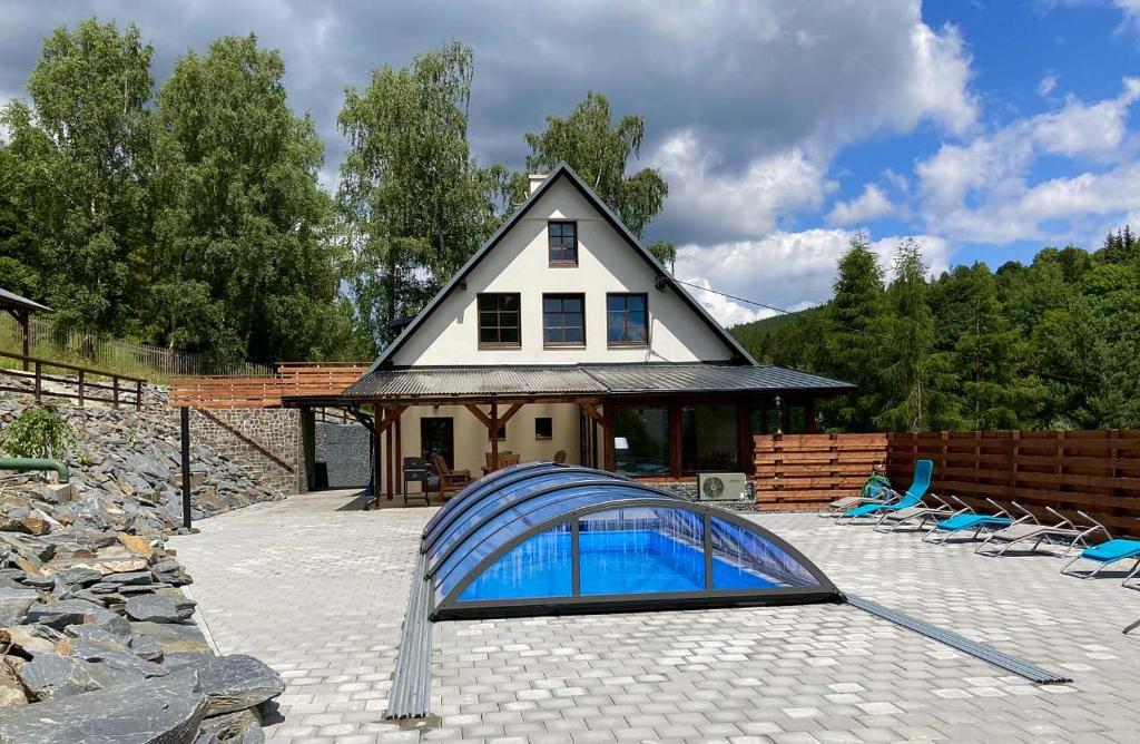 a house with a blue pool in front of a house at Apartmány Stará Voda in Stará Voda