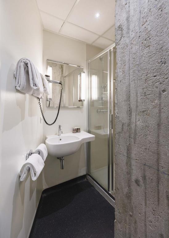 a bathroom with a sink and a shower at Hôtel de Noailles in Lyon