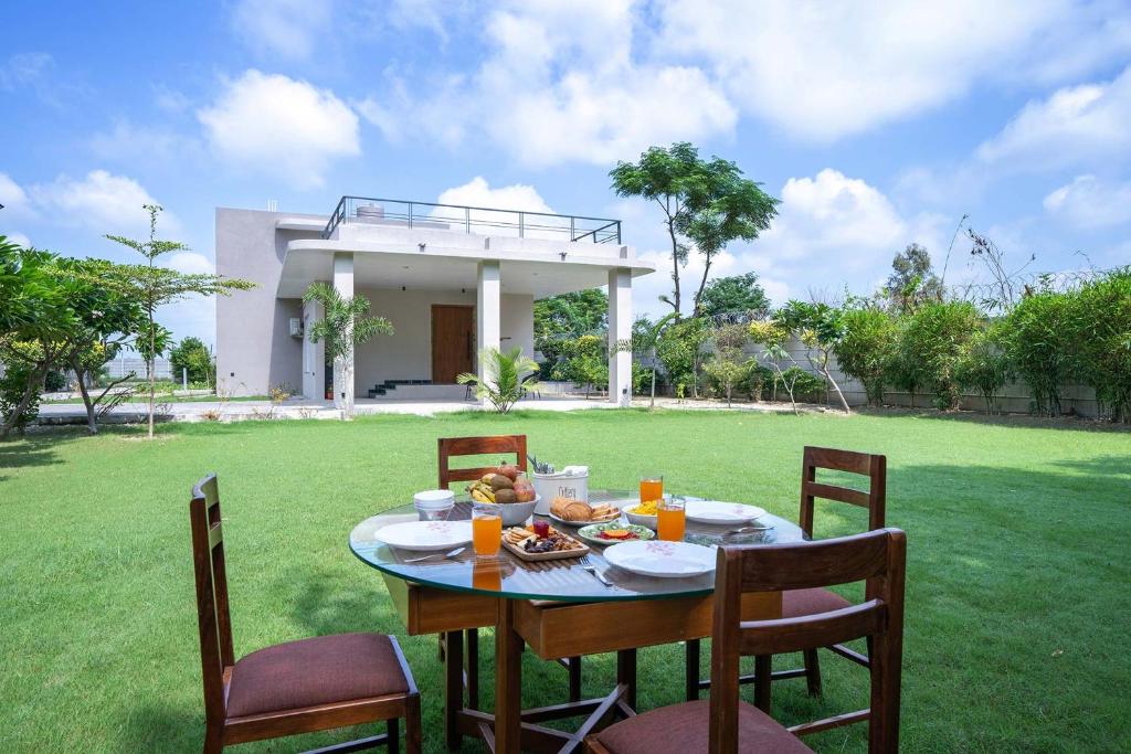 a table with food on it in front of a house at StayVista at Sukoon with Bonfire in Lucknow