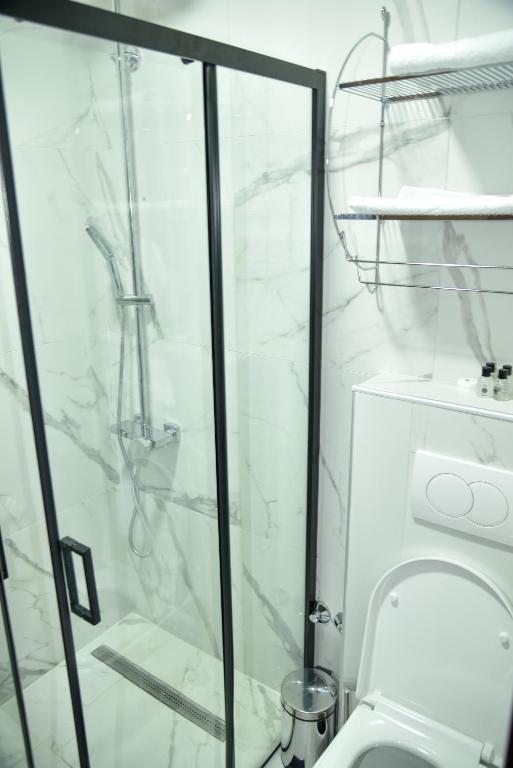 a bathroom with a shower and a toilet at Apartmani COLOSSEUM in Bratunac