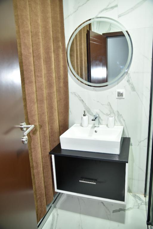 a bathroom with a sink and a mirror at Apartmani COLOSSEUM in Bratunac