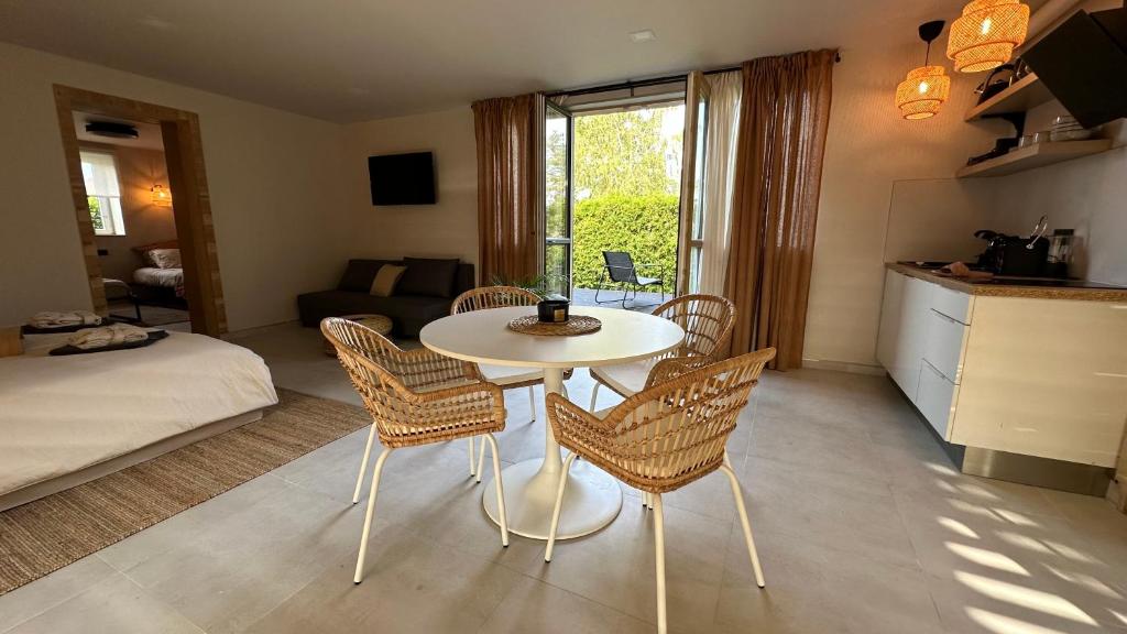 sala de estar con mesa blanca y sillas en ULU House With Terrace & Hot Tub en Mārupe
