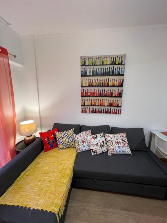 um sofá preto com almofadas na sala de estar em Apartamento Vasco da Gama em Lisboa