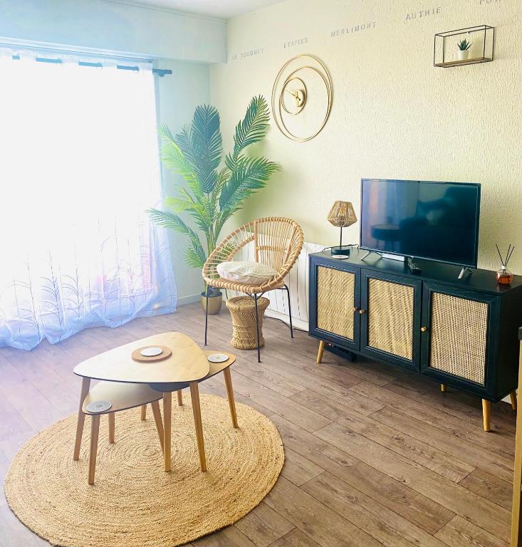 un salon avec une télévision et une table dans l'établissement Studio Entre MER ET DUNES avec balcon vue laterale MER 50m plage pour 3 pers wifi ménage compris, à Fort-Mahon-Plage