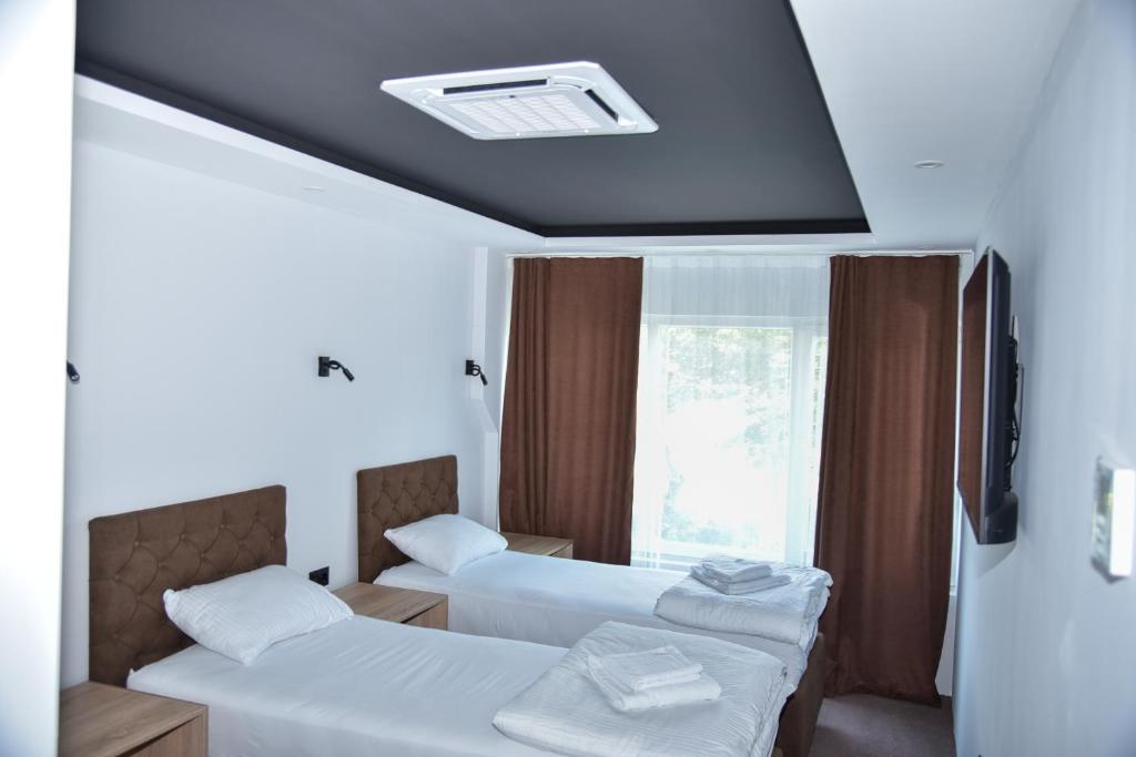 a hotel room with two beds and a window at Apartmani COLOSSEUM in Bratunac