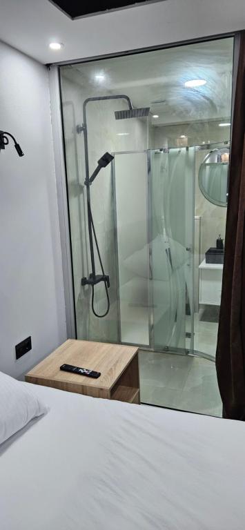 a shower in a room with a bed and a window at Apartmani COLOSSEUM in Bratunac