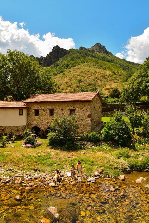 a group of people sitting in the grass near a house at El Molino de Nocedo in León