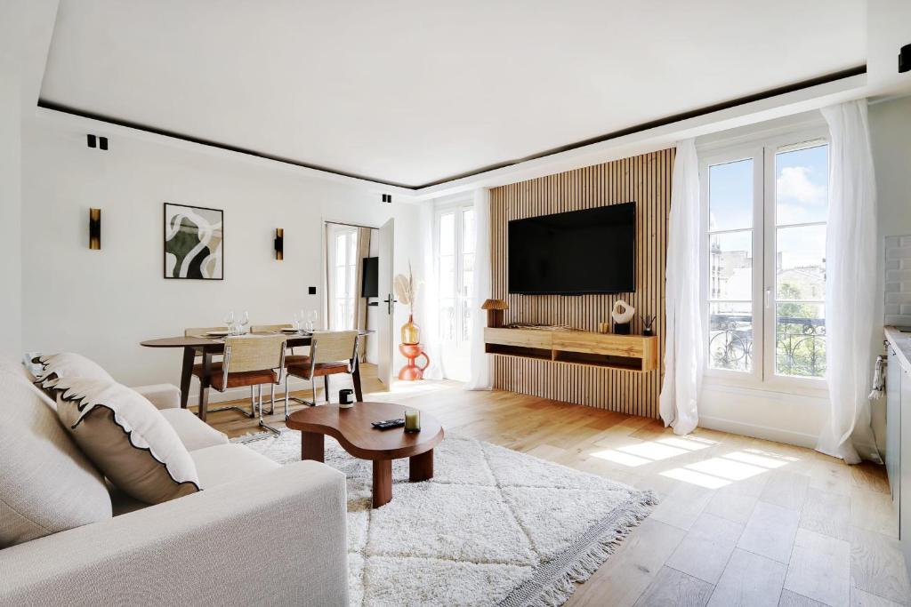 ein Wohnzimmer mit einem weißen Sofa und einem Tisch in der Unterkunft OLYMPIADES - PATAY Beautiful apartment in Paris