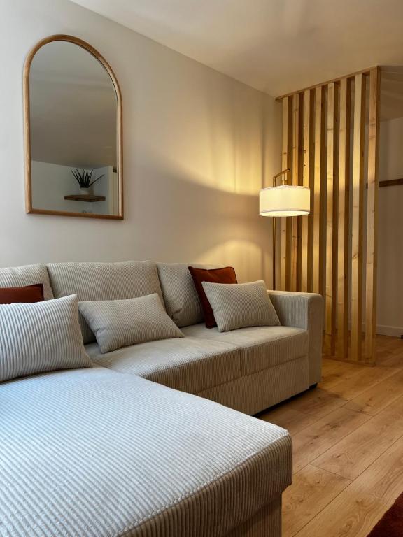 un soggiorno con divano e specchio di Appartement Le O'mehr a Saint-Omer