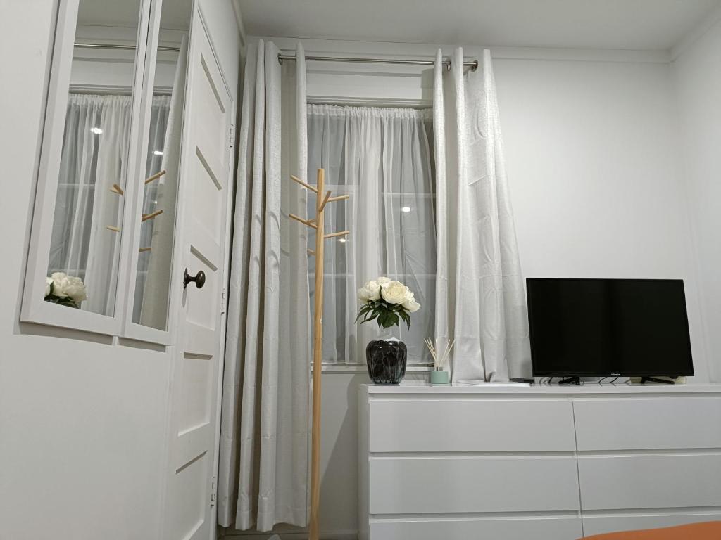 a white room with a tv and a window at Santos Place in Auckland