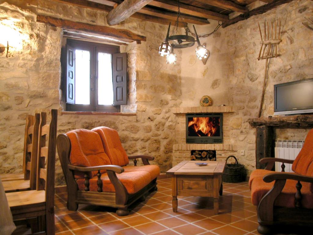 a living room with two chairs and a fireplace at Las Casas del Duraton in Urueñas