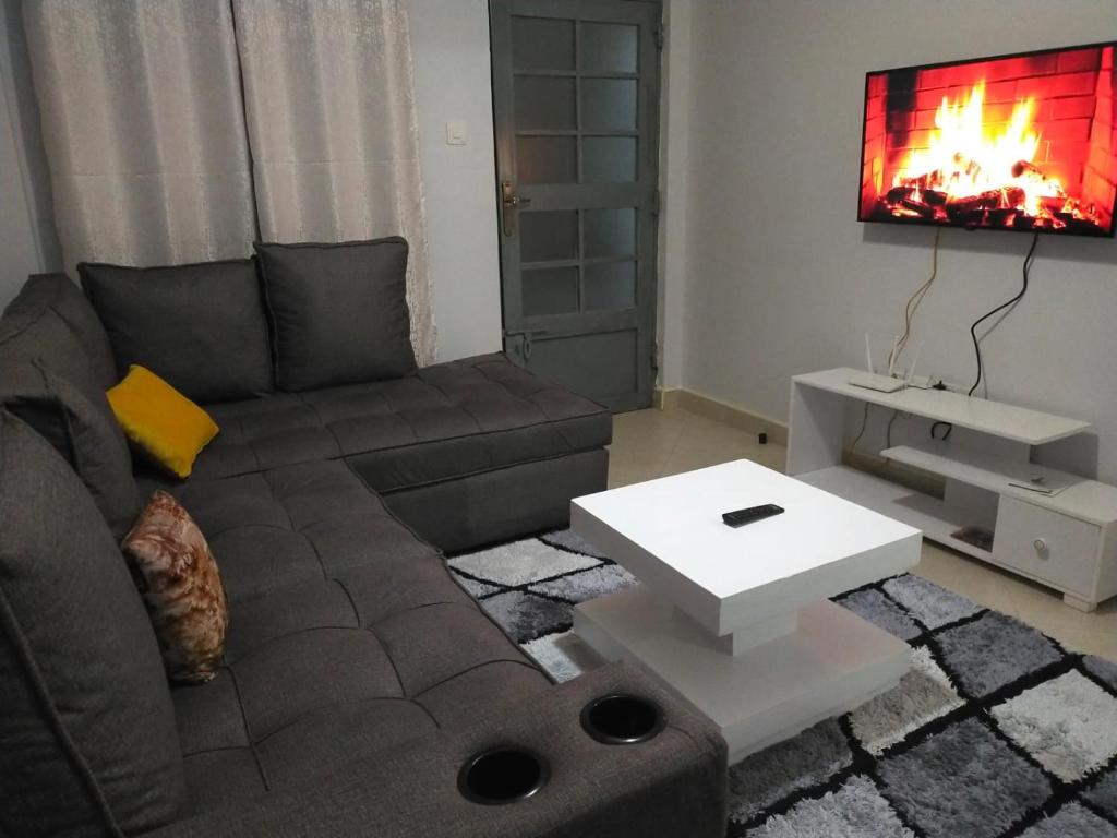 a living room with a couch and a tv at Carlyle comfort home in Thika