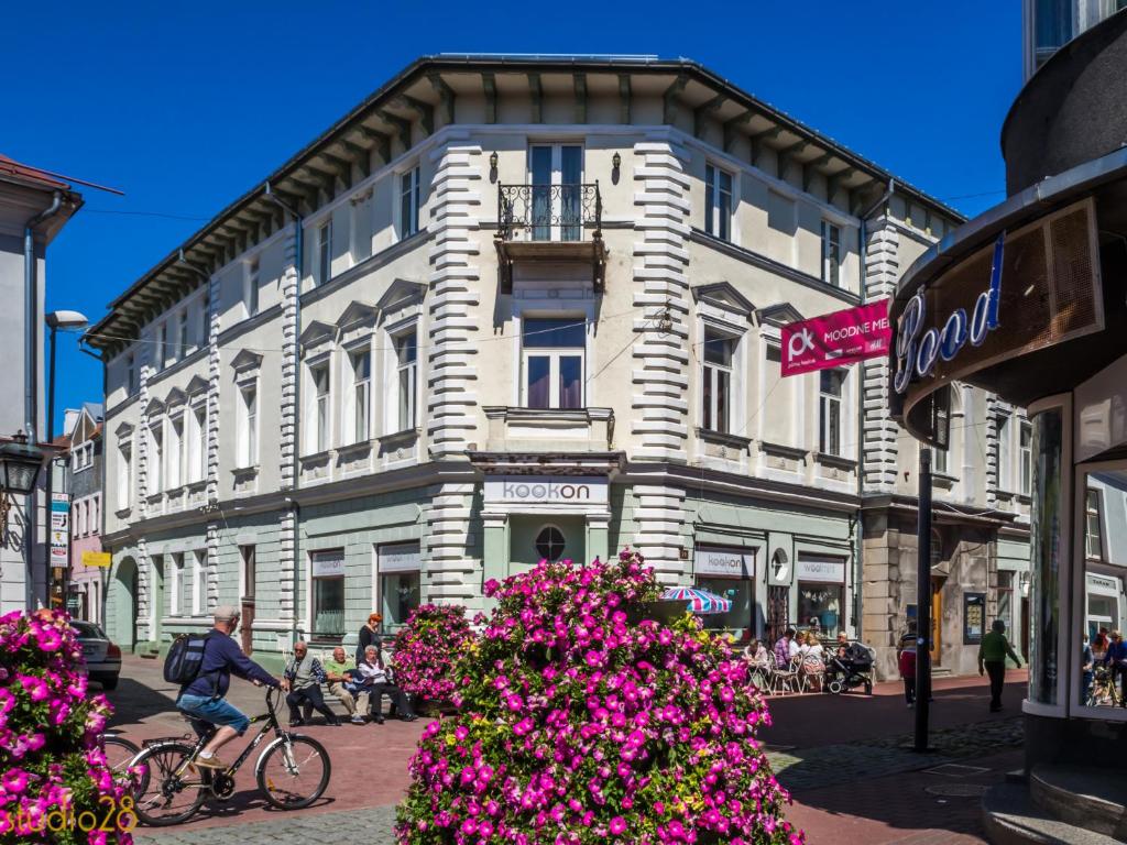 a man riding a bike in front of a building at Studio28 Boutique Rooms in Pärnu
