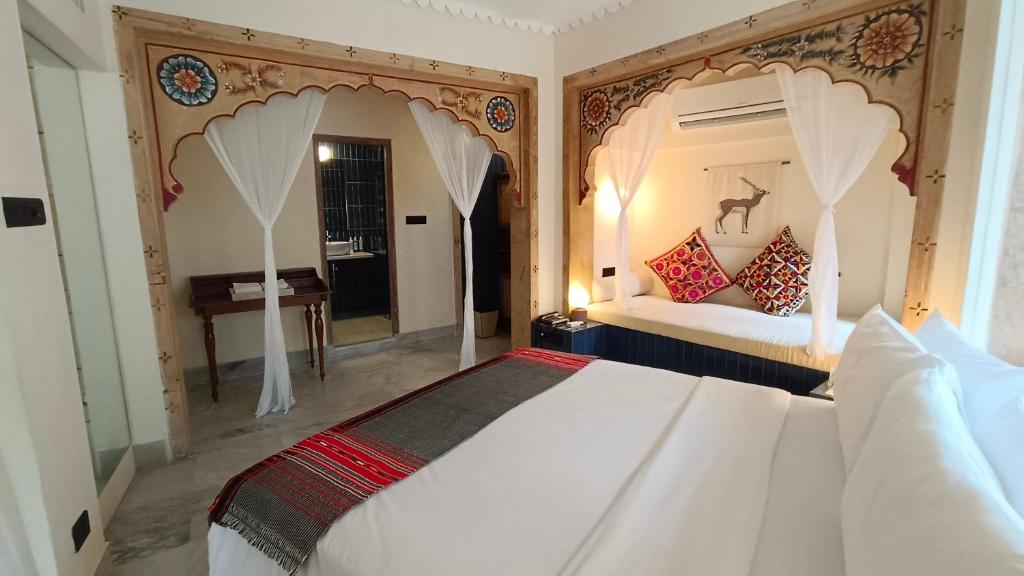 a bedroom with a large white bed and a mirror at The Stepwell Hotel in Jodhpur