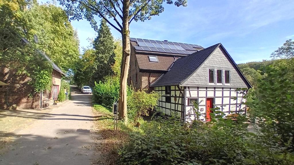 uma pequena casa com telhado solar numa rua em Feierabend im Grünen em Haan