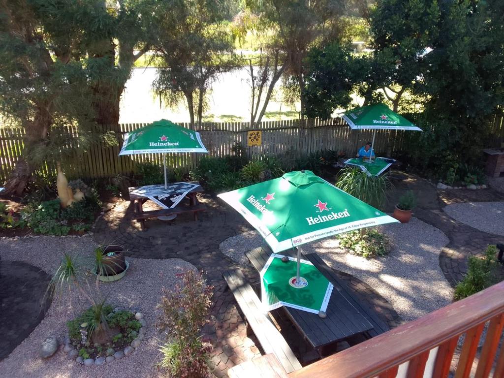 a patio with two green umbrellas and a bench at Tiffanys B&B, Pub & and Teagarden in Sedgefield