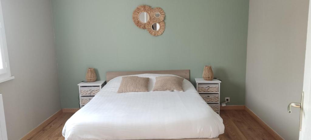 a bedroom with a white bed and two night stands at à l'air du Mont in Roz-sur-Couesnon