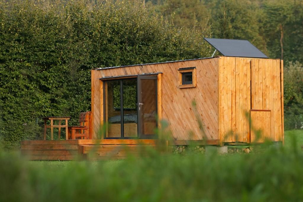 a wooden tiny house in a field of grass at Obytný kontejner Cabin Stars in Zátor