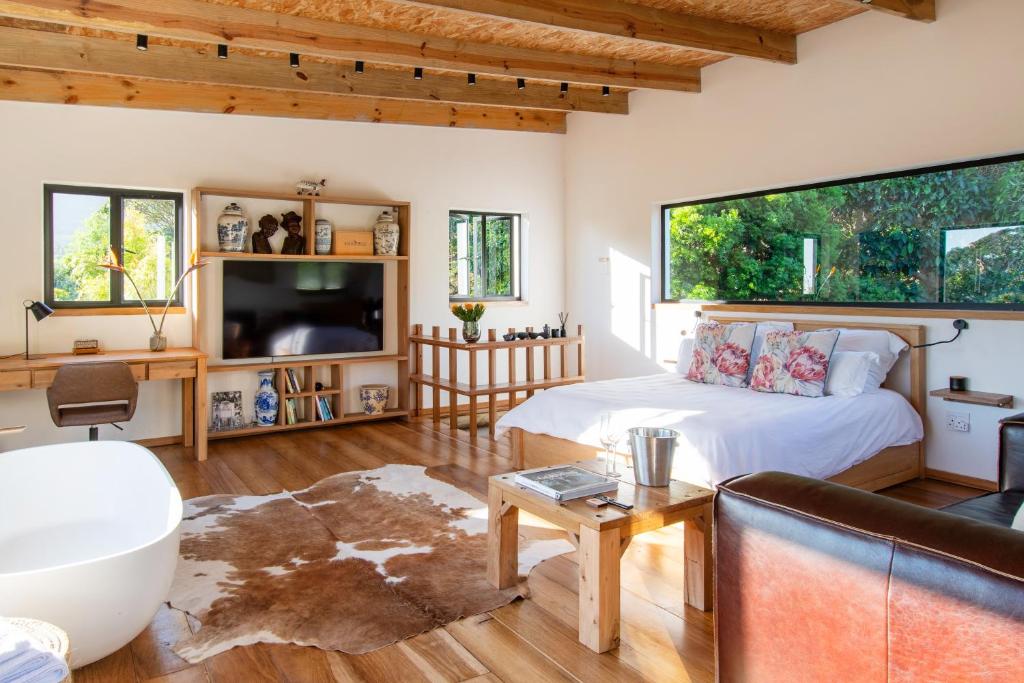 salon z łóżkiem i kanapą w obiekcie Granite Forest Chalet w Kapsztadzie