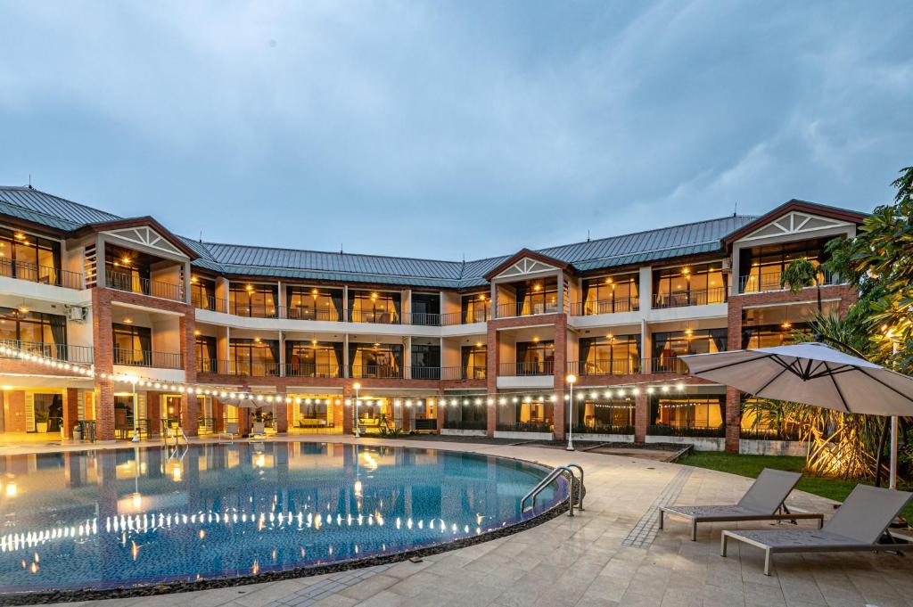 an exterior view of a hotel with a swimming pool at Eco Hotel by Thammasat in Bang Lamung