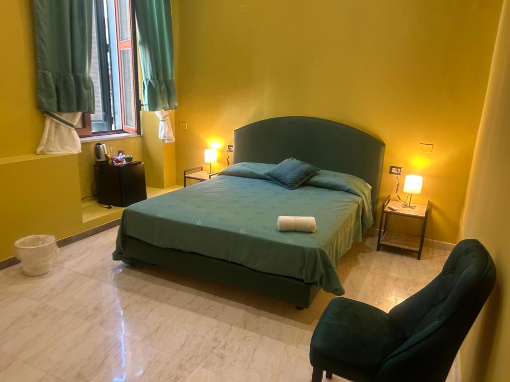 ein Schlafzimmer mit einem grünen Bett und einem Stuhl in der Unterkunft Venus of Milo in Neapel