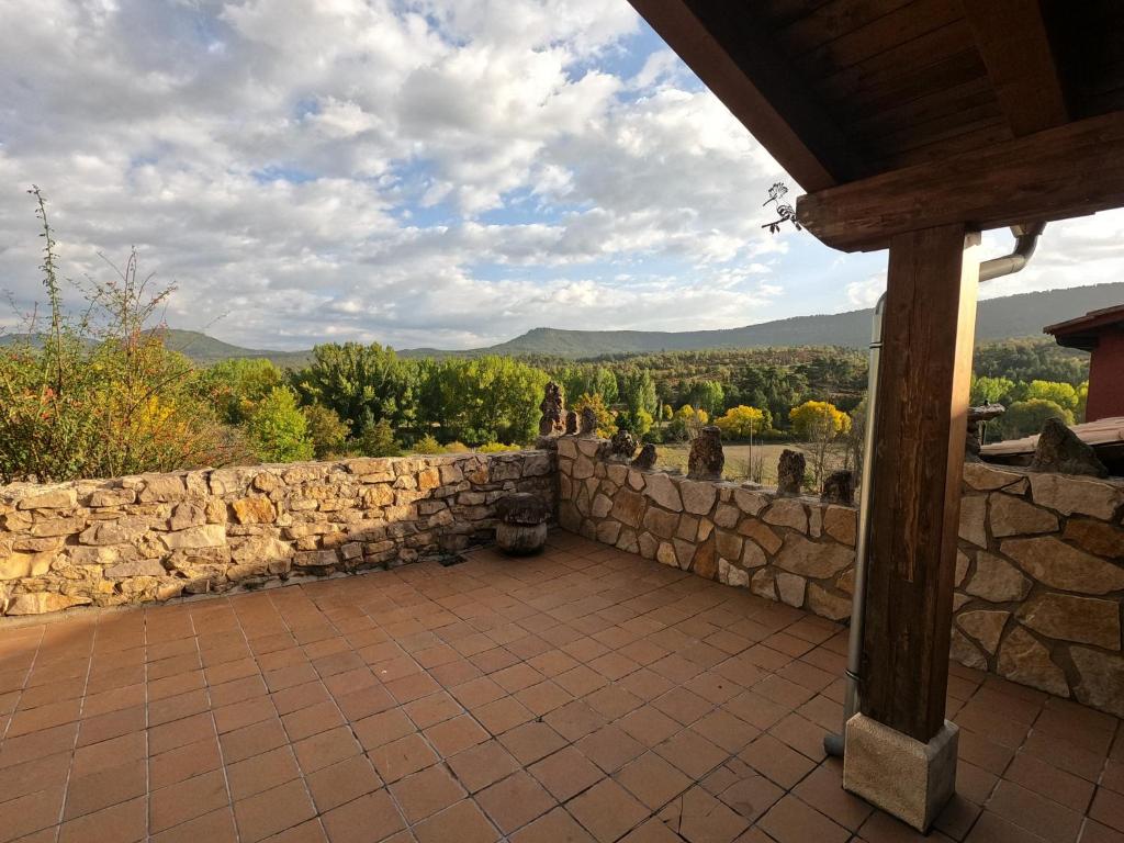 a stone wall and a patio with a view at Casa el Escalerón in Uña