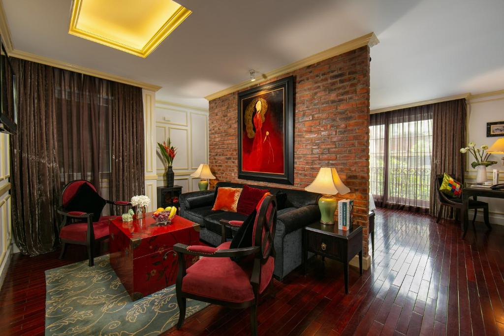 ein Wohnzimmer mit Sofa und Ziegelwand in der Unterkunft Hanoi Boutique Hotel & Spa in Hanoi