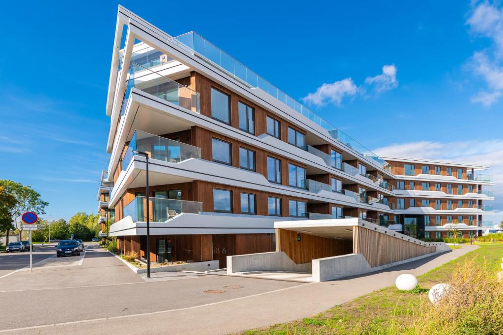 duży budynek z parkingiem przed nim w obiekcie Hilltop Apartments - Kiikri Residence City Centre w Tallinnie
