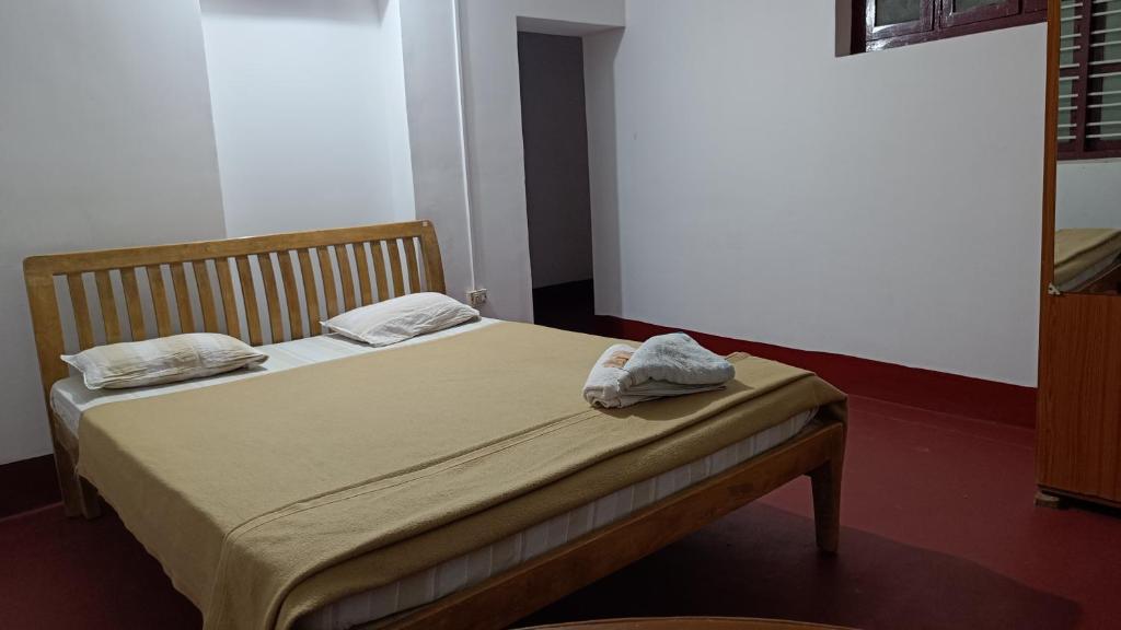 a bedroom with a bed with two towels on it at O2 estate stay in Virajpet