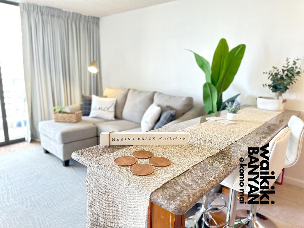 uma sala de estar com uma mesa e um sofá em Stunning 1BD a block away to Waikiki Beach Free Parking em Honolulu